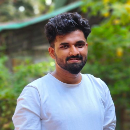 Professional portrait of Amit Chaurasia, a young Indian male video editor with a creative look, standing in a studio environment